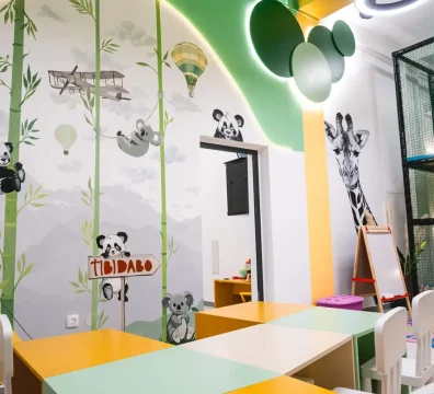 Prikaz dizajna na zidovima igraonice koji krase zanimljive dečije animacije životinja kao što su pande i žirafe.