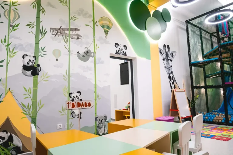 Prikaz dizajna na zidovima igraonice koji krase zanimljive dečije animacije životinja kao što su pande i žirafe.