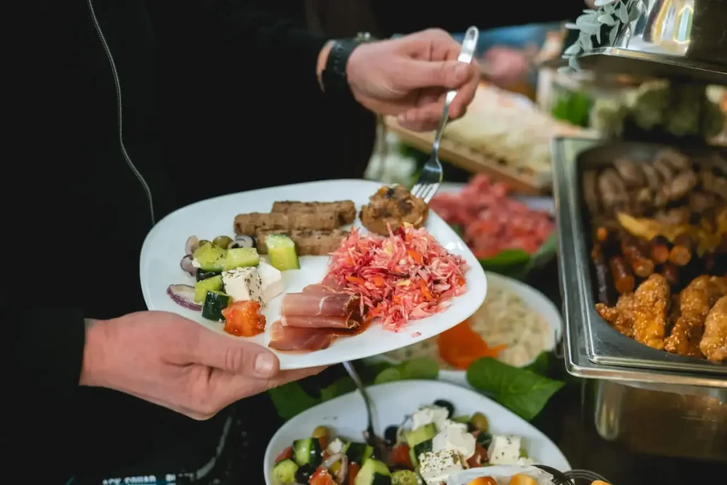 Švedski sto za roditelje koji čine više vrsta mesa sa roštilja, više vrsta svežih salata, peciva, bogato predjelo, dezert